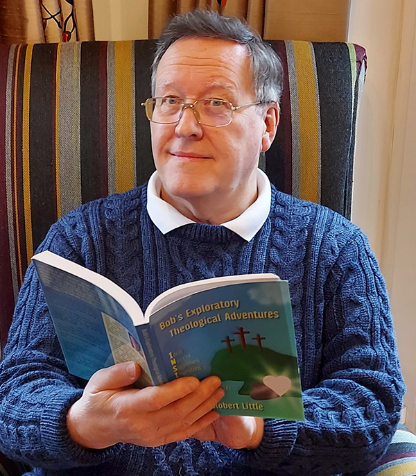 Bob Little seated with one of his published books